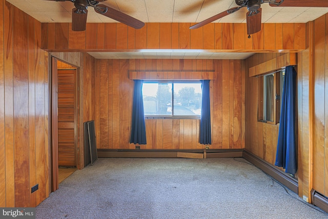 carpeted empty room with wood walls and ceiling fan