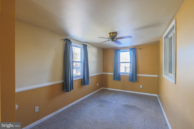 carpeted spare room featuring ceiling fan and a healthy amount of sunlight