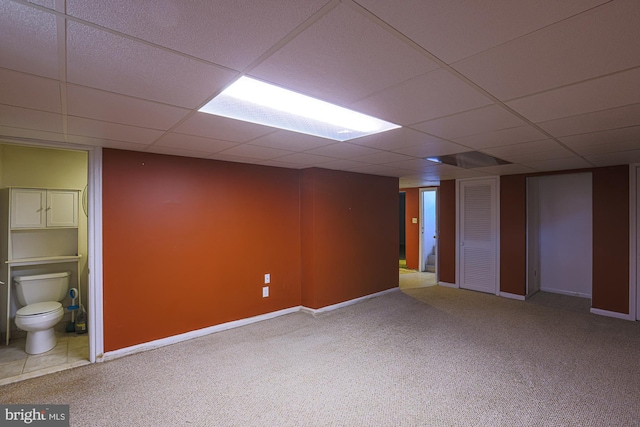 basement featuring a paneled ceiling and carpet floors