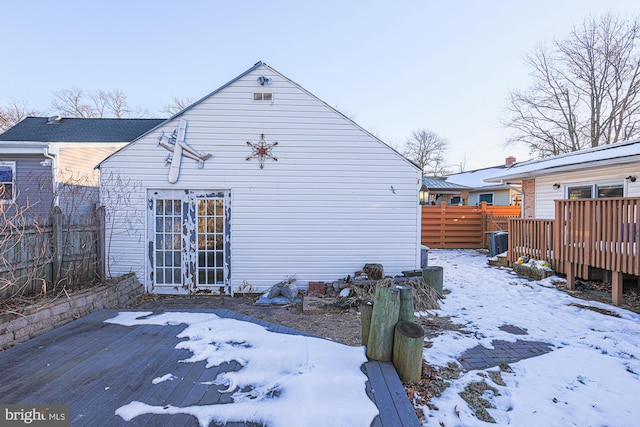 snow covered house featuring a wooden deck