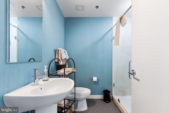 bathroom with tile patterned floors, toilet, sink, and walk in shower