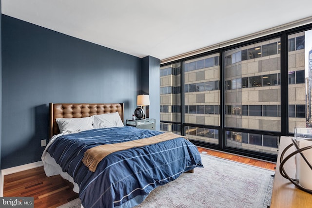 bedroom featuring wood-type flooring and expansive windows