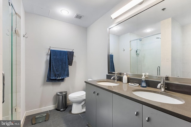 bathroom with tile patterned flooring, a shower with door, vanity, and toilet