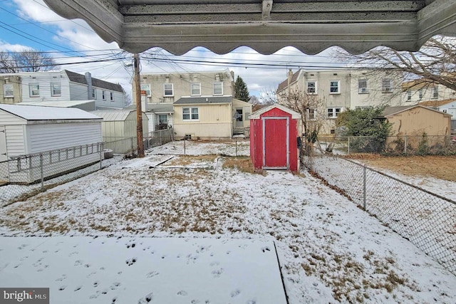 yard layered in snow with a shed