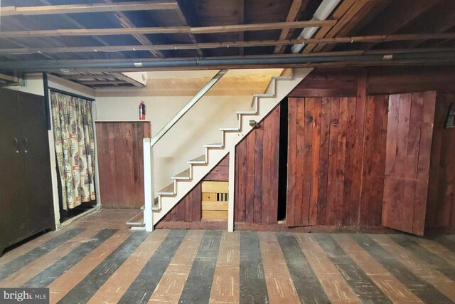 basement featuring wooden walls