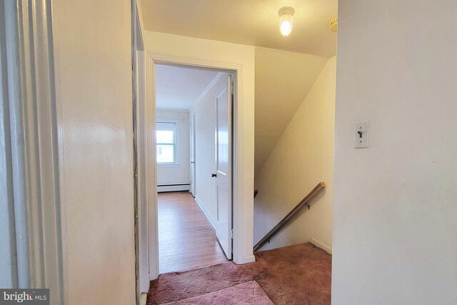 hallway with carpet and baseboard heating