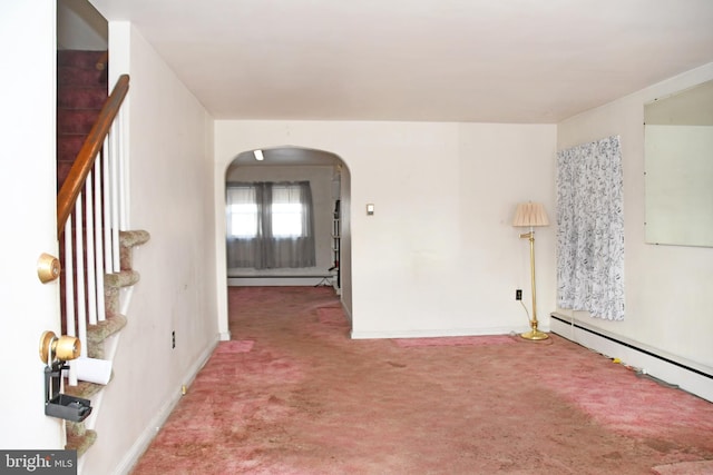 carpeted empty room featuring a baseboard heating unit