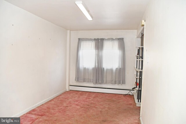 spare room with baseboard heating and light colored carpet