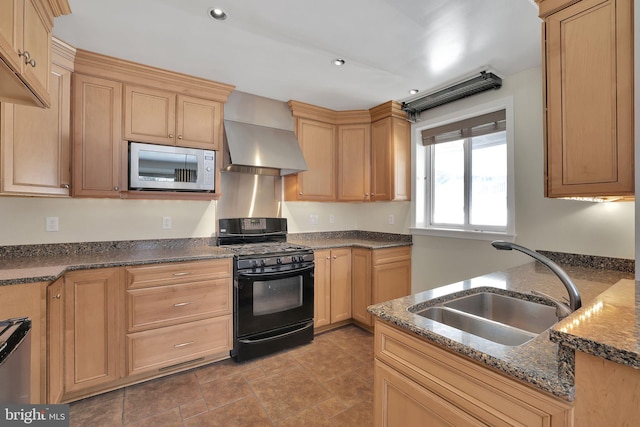 kitchen with built in microwave, sink, wall chimney exhaust hood, black gas range oven, and dark stone counters