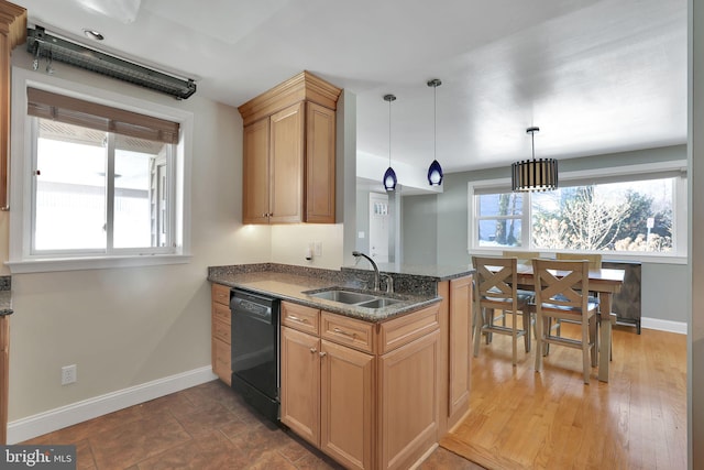 kitchen with dark stone countertops, sink, decorative light fixtures, and black dishwasher