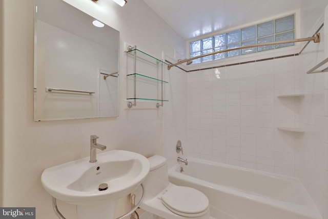 full bathroom with sink, tiled shower / bath combo, and toilet