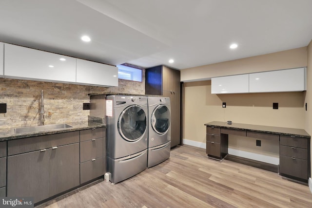 washroom featuring separate washer and dryer, sink, and light wood-type flooring