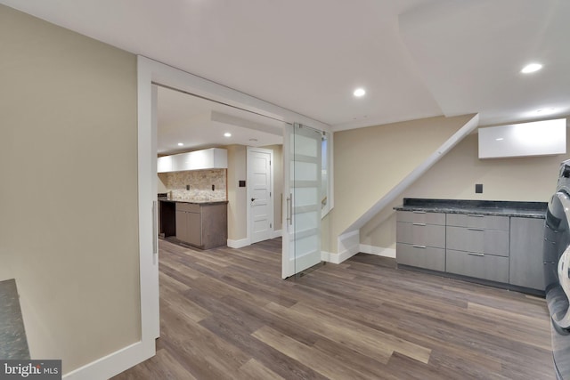 kitchen with tasteful backsplash and dark wood-type flooring