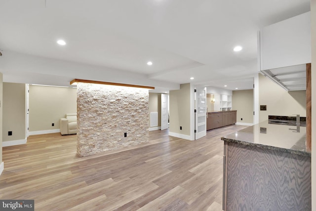 unfurnished living room featuring light hardwood / wood-style flooring and sink