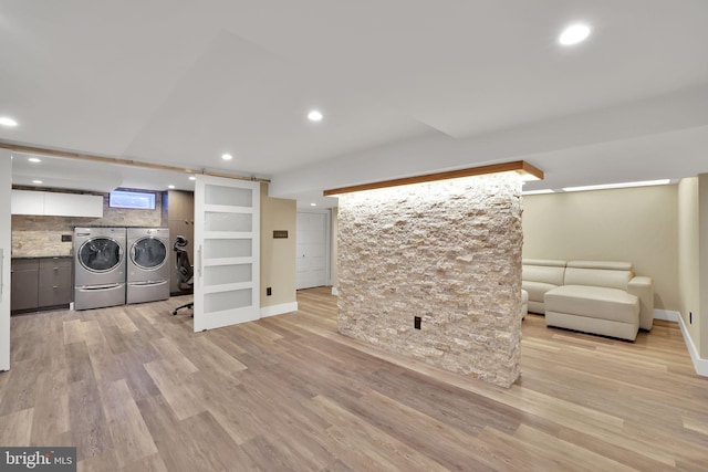 clothes washing area featuring built in shelves, separate washer and dryer, and light hardwood / wood-style floors