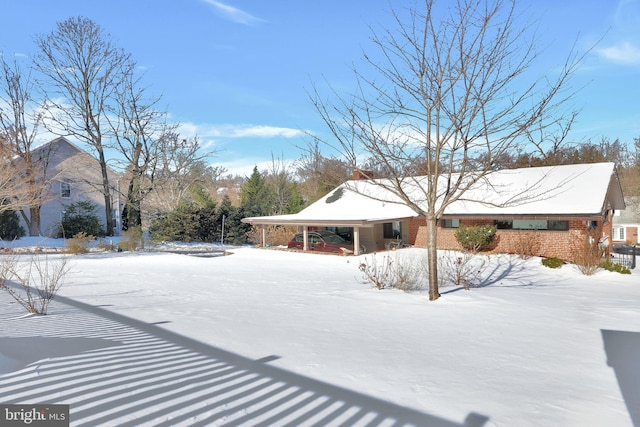 yard covered in snow featuring a carport