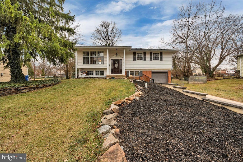 raised ranch featuring a front lawn and a garage