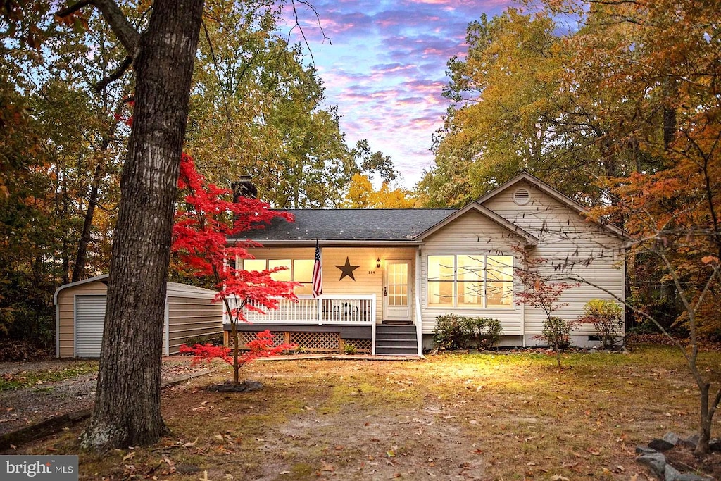 view of front facade featuring ceiling fan, a porch, and an outdoor structure