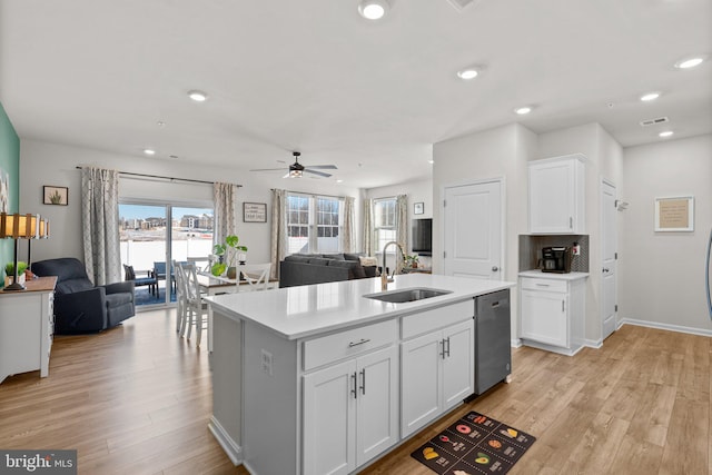 kitchen with ceiling fan, sink, a center island with sink, dishwasher, and white cabinetry