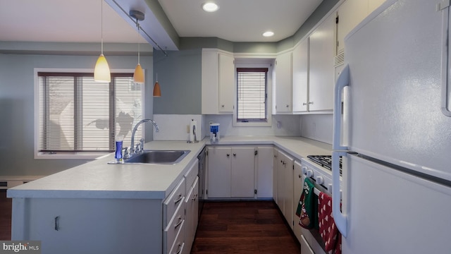 kitchen featuring white cabinets, sink, white fridge, and decorative light fixtures