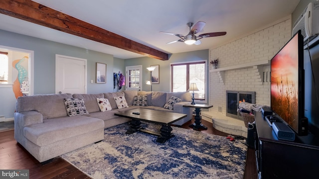 living room with a fireplace, beam ceiling, dark wood-type flooring, and ceiling fan