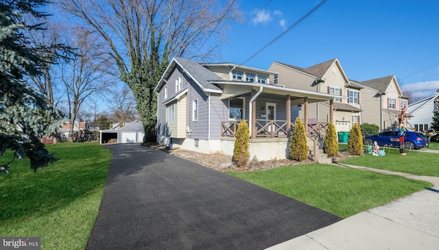 view of front facade with a porch, a garage, an outbuilding, and a front yard