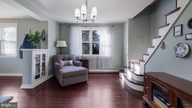 living area with dark hardwood / wood-style flooring, baseboard heating, and an inviting chandelier