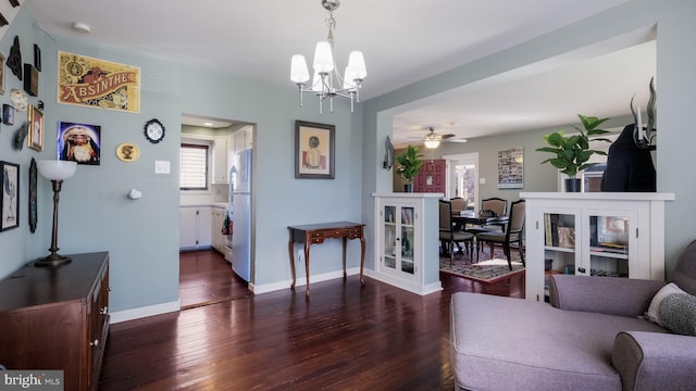 living room featuring dark hardwood / wood-style flooring and ceiling fan with notable chandelier