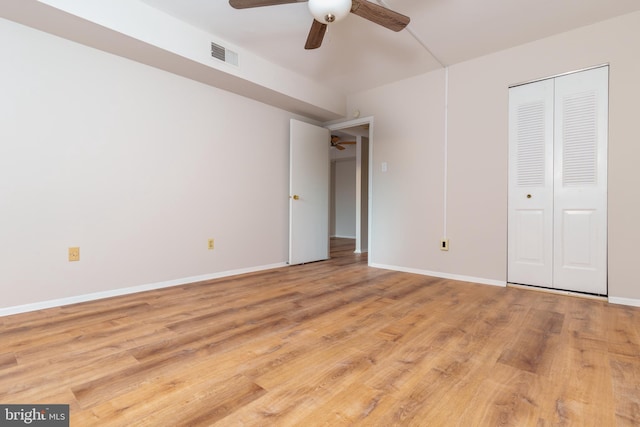 unfurnished bedroom with ceiling fan, light wood-type flooring, and a closet