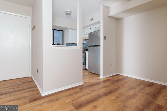 kitchen with white cabinetry, light hardwood / wood-style flooring, and stainless steel appliances