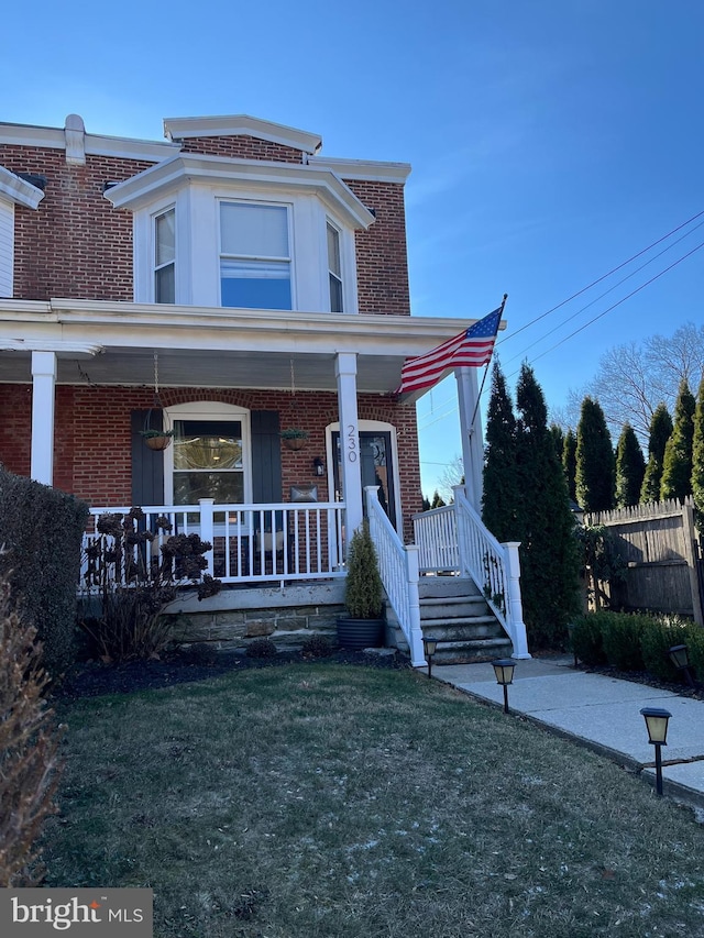 view of front facade featuring covered porch and a front lawn