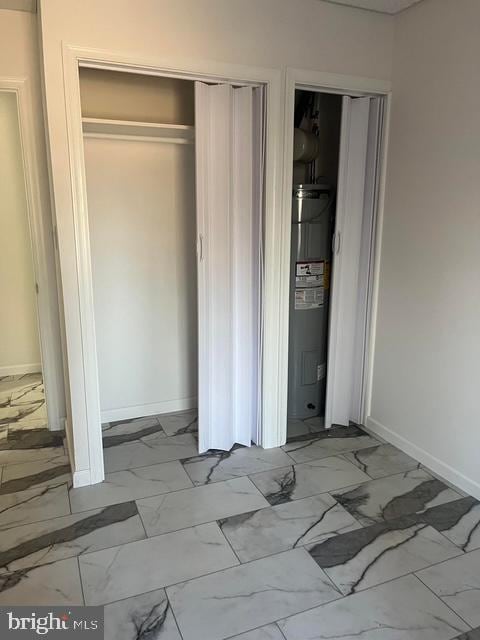 unfurnished bedroom with a closet and electric water heater