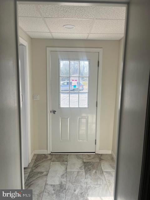 doorway to outside featuring a paneled ceiling