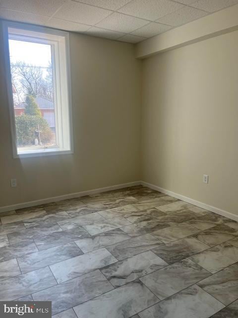 unfurnished room featuring a drop ceiling