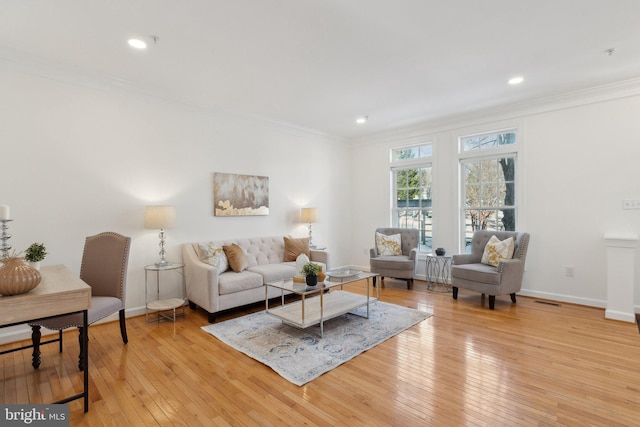 living room featuring crown molding and light hardwood / wood-style flooring