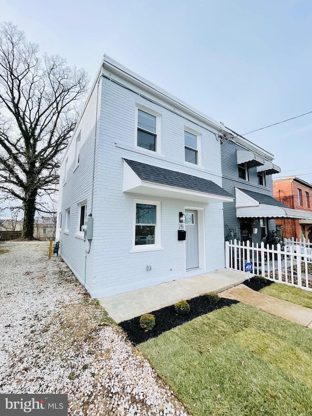 view of front of home with brick siding and fence