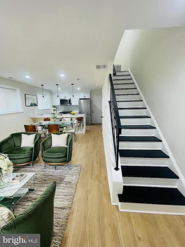 stairs featuring hardwood / wood-style floors