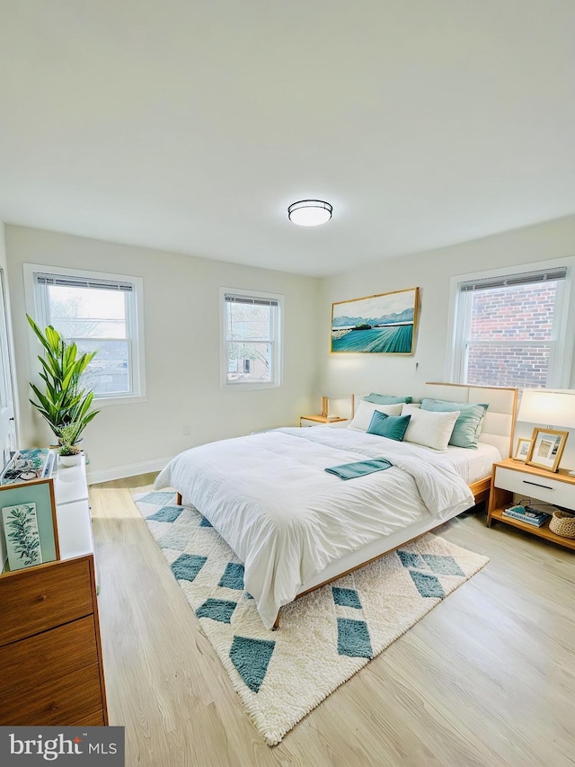 bedroom featuring light hardwood / wood-style flooring and multiple windows