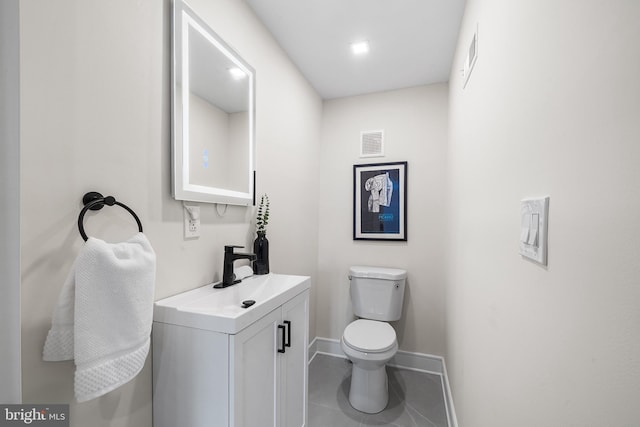 bathroom featuring toilet, vanity, and tile patterned floors