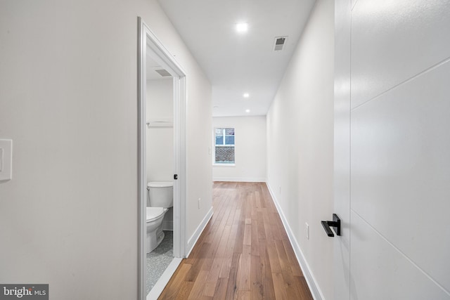 hallway with hardwood / wood-style flooring