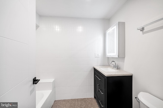 bathroom with tile walls, a tub, vanity, and toilet