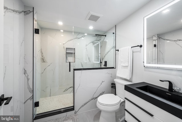 bathroom featuring vanity, a shower with shower door, and toilet