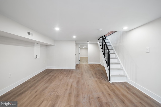 basement with light hardwood / wood-style flooring