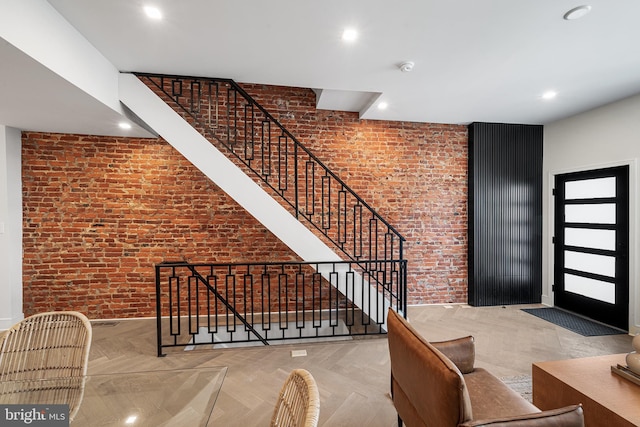 stairway with brick wall and parquet floors