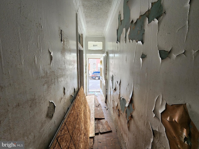 corridor with a textured ceiling and crown molding