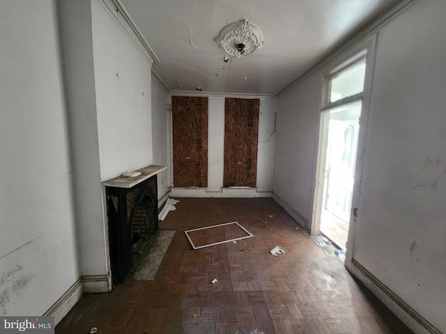 unfurnished living room with dark parquet flooring and ornamental molding