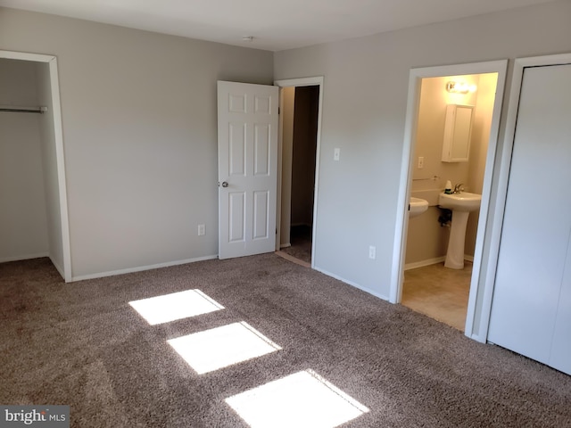 unfurnished bedroom with ensuite bath, sink, and carpet floors