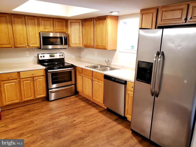 kitchen featuring sink, light wood-type flooring, and appliances with stainless steel finishes