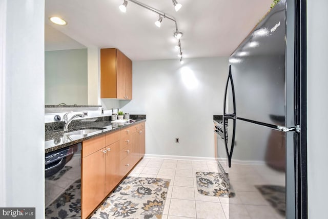 kitchen with dark stone countertops, sink, light tile patterned floors, and black appliances