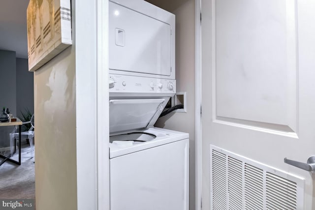 washroom featuring stacked washer / drying machine